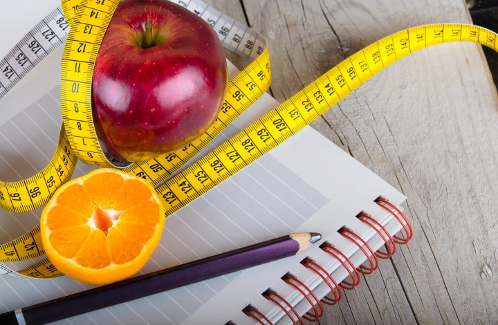 measuring tape, planner, and ready to eat fruit